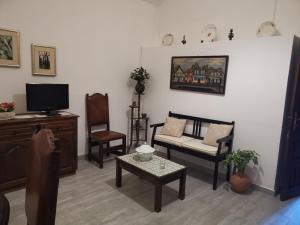 sala de estar con sofá, sillas y TV en Casa da Eira - Castanheiras, en Resende