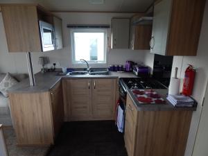 a small kitchen with a sink and a stove at Flamingo Land - Cedar Wood CW09 in Kirby Misperton