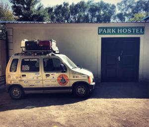 a white van parked in front of a building at Park Hostel Osh in Osh