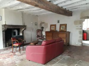 sala de estar con sofá rojo y sillas en Galerie Benjamine, en Vézelay