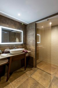a bathroom with a sink and a shower at Hôtel & Restaurant Sodade in Chaudes-Aigues