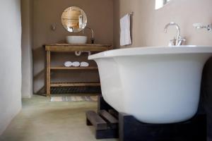 a bathroom with a white tub and a sink at African Game Lodge in Montagu