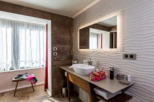 a bathroom with a sink and a mirror at Hôtel & Restaurant Sodade in Chaudes-Aigues