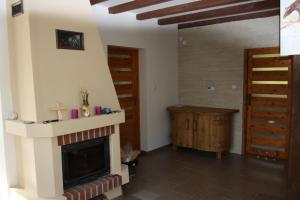 a living room with a fireplace and a wooden door at Domek Uherce Mineralne in Uherce Mineralne (7)