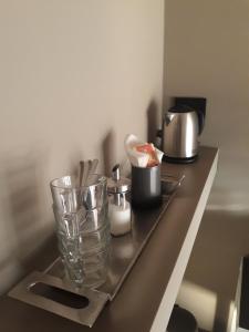 a counter with a glass vase and other items on it at CameLia in Ivrea