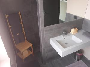a bathroom with a sink and a wooden chair at CameLia in Ivrea