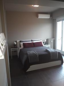 a bedroom with a large bed with red pillows at CameLia in Ivrea