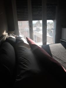 a bed with pillows in a room with a window at CameLia in Ivrea