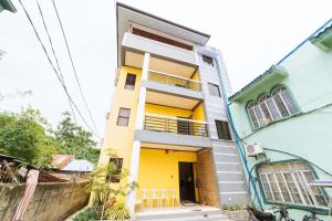 a house with yellow and blue paint at RedDoorz @ D Maagma Street in Kalibo