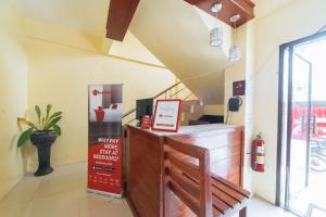 a restaurant with a bench and stairs in a room at RedDoorz @ D Maagma Street in Kalibo