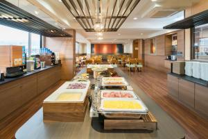 a buffet line with trays of food in a restaurant at Vessel Hotel Kurashiki in Kurashiki