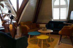 una habitación con sofás, mesas y ventanas en Charming Suites Jan Zonder Vrees en Amberes
