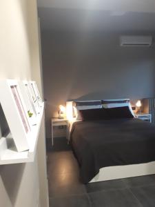 um quarto com uma cama preta e duas mesas de cabeceira em CameLia em Ivrea