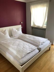ein weißes Bett in einem Schlafzimmer mit einem Fenster in der Unterkunft Hotel Pflieger in Pocking