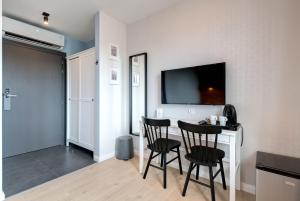 Cette chambre dispose de 2 chaises, d'une table et d'une télévision. dans l'établissement Apartamenty Bema4 Sopot, à Sopot