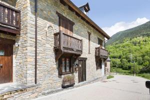 a stone building with wooden balconies on the side of it at Luderna - Dúplex con jardín des Treuetes in Gessa
