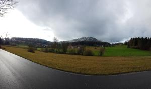 an empty road with a field and a mountain at Hotel Platzhirsch in Gaggenau