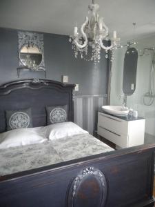 a bedroom with a bed and a sink and a chandelier at Les Terrasses du Lac- Villa Le LAC Cottage au Bord du Lac d'Annecy - in Veyrier-du-Lac