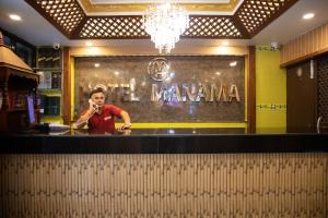 Una mujer parada en un bar hablando por celular en OYO 304 Hotel Manama, en Bālāju