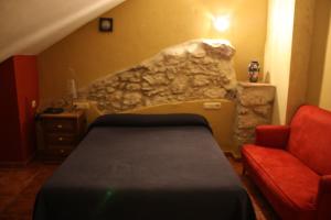 ein Schlafzimmer mit einem Bett und einer Steinwand in der Unterkunft Hotel Don Pero in Alora
