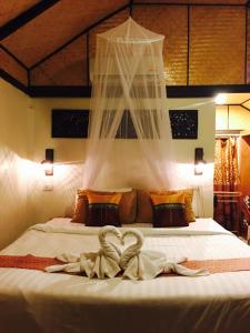 een slaapkamer met een bed met een witte sprei bij Nautilus Right on the Beach - Adult Only - SHA Extra Plus in Koh Lanta