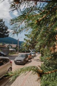 eine Reihe von Autos parkten auf einer Stadtstraße in der Unterkunft Good Vibes Apartment in Câmpulung Moldovenesc