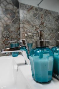 eine blaue Flasche Seife auf einem Waschbecken in der Unterkunft Good Vibes Apartment in Câmpulung Moldovenesc
