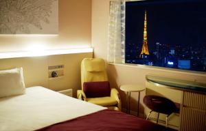 a hotel room with a bed and a view of the eiffel tower at remm Roppongi in Tokyo