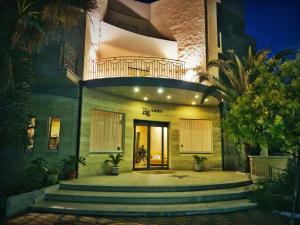 a building with stairs leading to a door with a balcony at Hotel Mille Pini in Ginosa Marina
