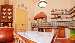 uma cozinha com uma mesa, cadeiras e um fogão em Casa Barone Agnello em Cefalù