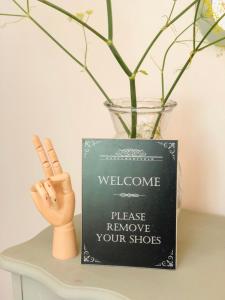 a sign sitting on a table next to a vase at Happy Bentveld Guesthouse in Bentveld