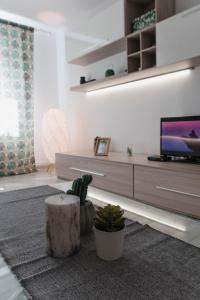 ein Wohnzimmer mit einer Couch, einem Fernseher und einem Tisch in der Unterkunft Good Vibes Apartment in Câmpulung Moldovenesc