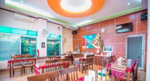 jadalnia ze stołami i krzesłami w restauracji w obiekcie BANDER HOTEL w mieście Phu Khieo