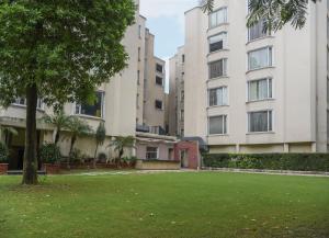 um jardim relvado em frente a dois edifícios altos em Sarovar Portico Surajkund em Nova Deli
