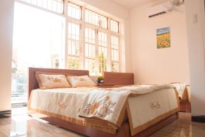 ein Schlafzimmer mit einem Bett und einem großen Fenster in der Unterkunft Blossom Homestay in Tuy Hoa