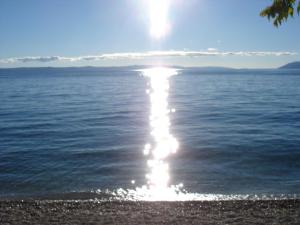 a reflection of the sun in the water at Apartments Malina in Tučepi