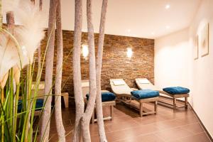 uma sala de espera com cadeiras e uma parede de tijolos em Brauers Landarthotel GmbH em Daun