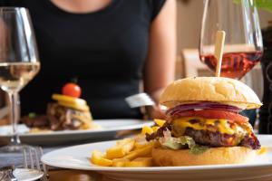une assiette avec un cheeseburger et des frites sur une table dans l'établissement Brauers Landarthotel GmbH, à Daun