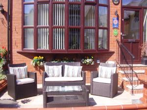 tres sillas de mimbre y una mesa frente a un edificio en Langtrys, en Blackpool