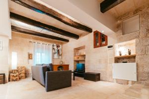 a living room with a fireplace and a stone wall at 120 Lapsi Apartments in St. Julianʼs