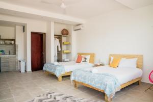 a bedroom with two beds and a kitchen at dewl estudios & residences : THE KAHLO in Playa del Carmen +34 photos