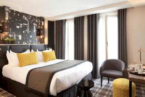 una camera d'albergo con un grande letto e una sedia di Le Grey Hotel a Parigi Altre 55 foto