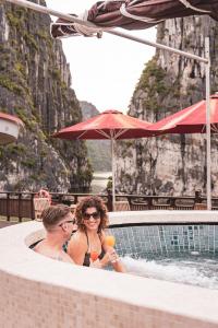 a man and a woman sitting in a hot tub at Heritage Line Ginger Cruise - Halong Bay & Lan Ha Bay in Ha Long