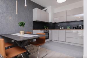 a kitchen with a table, chairs and a refrigerator at TK HOMES in Budapest