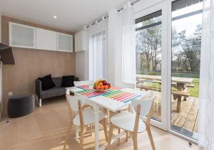 a kitchen and dining room with a table and chairs at Camping des Gayeulles in Rennes