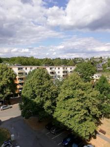 埃森的住宿－Single-Apartment Essen，停车场内有几棵树,有建筑物
