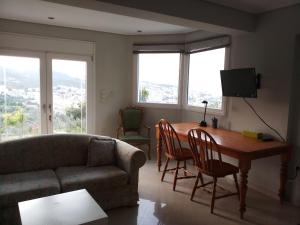 a living room with a table and chairs and a couch at Studio Mytilene View in Mytilini