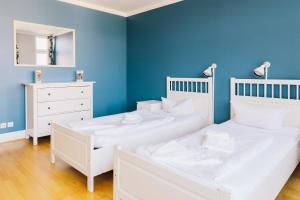 two beds in a room with a blue wall at St Christopher's Apartments in Berlin