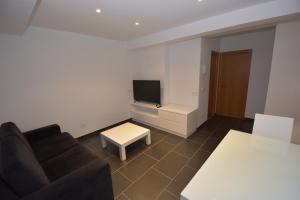 a living room with a couch and a tv at INMOMILCASAS APARTAMENTOS in Noya