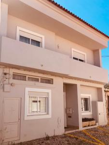 a house with a garage in front of it at Casa da Aldeia - Guest House in Odiáxere